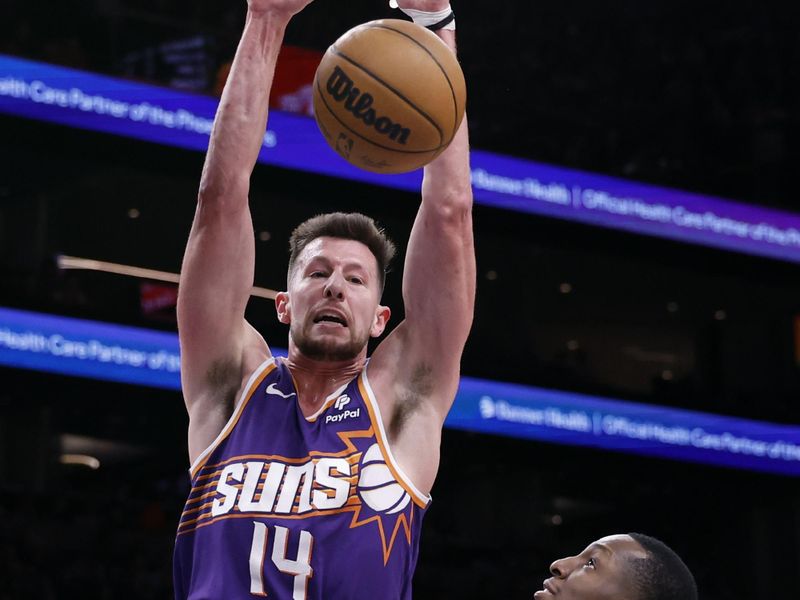 PHOENIX, ARIZONA - MARCH 21: Drew Eubanks #14 of the Phoenix Suns dunks over Onyeka Okongwu #17 of the Atlanta Hawks during the second half at Footprint Center on March 21, 2024 in Phoenix, Arizona. NOTE TO USER: User expressly acknowledges and agrees that, by downloading and or using this photograph, User is consenting to the terms and conditions of the Getty Images License Agreement.  (Photo by Chris Coduto/Getty Images)