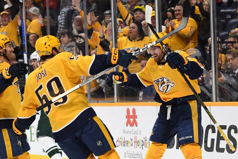 Feb 29, 2024; Nashville, Tennessee, USA; Nashville Predators center Yakov Trenin (13) celebrates with teammates after a goal during the first period against the Minnesota Wild at Bridgestone Arena. Mandatory Credit: Christopher Hanewinckel-USA TODAY Sports