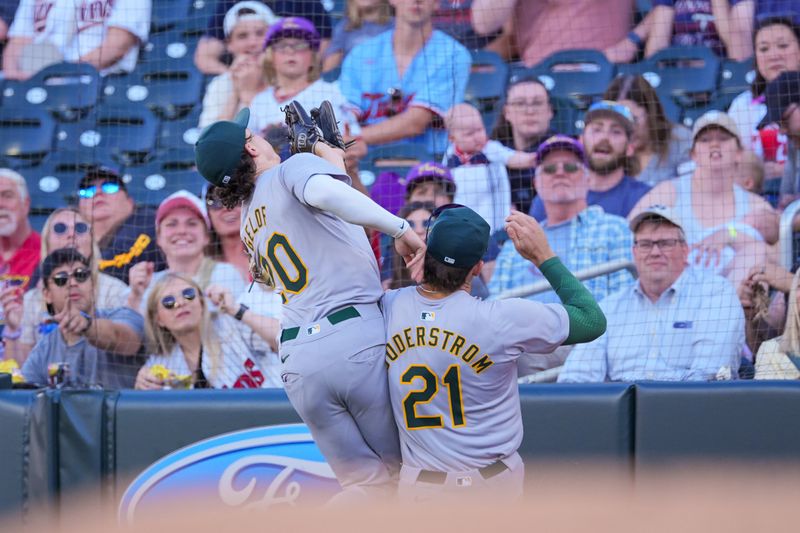 Jun 13, 2024; Minneapolis, Minnesota, USA; Oakland Athletics second base Zack Gelof (20) and first base Tyler Soderstrom (21) collide catching a fly ball against the Minnesota Twins in the second inning at Target Field. Mandatory Credit: Brad Rempel-USA TODAY Sports