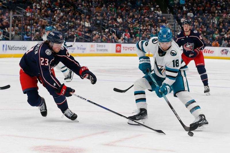 Mar 16, 2024; Columbus, Ohio, USA; San Jose Sharks right wing Filip Zadina (18) carries the puck as Columbus Blue Jackets defenseman Jake Christiansen (23) defends during the first period at Nationwide Arena. Mandatory Credit: Russell LaBounty-USA TODAY Sports