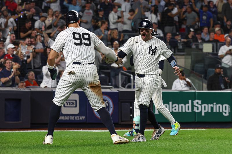 Sep 26, 2024; Bronx, New York, USA; New York Yankees catcher Austin Wells (28) celebrates with center fielder Aaron Judge (99) after scoring a run during the sixth inning against the Baltimore Orioles at Yankee Stadium. Mandatory Credit: Vincent Carchietta-Imagn Images