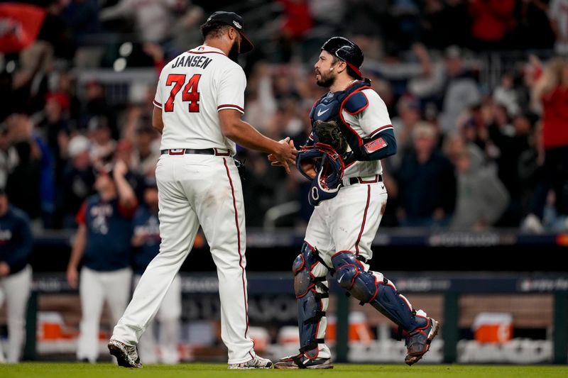 Oct 12, 2022; Atlanta, Georgia, USA; Atlanta Braves relief pitcher Kenley Jansen (left) shakes hands with catcher Travis d'Arnaud (16) after the final out against the Philadelphia Phillies in the ninth inning during game two of the NLDS for the 2022 MLB Playoffs at Truist Park. Mandatory Credit: Dale Zanine-USA TODAY Sports