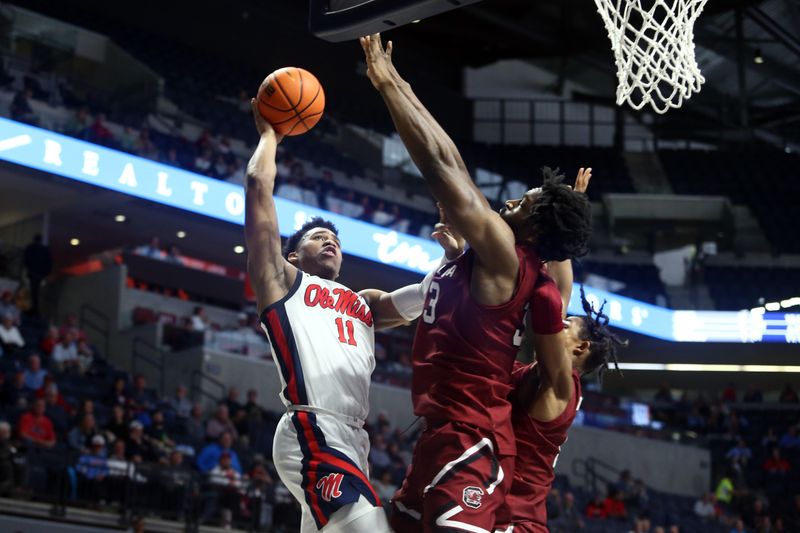 Feb 11, 2023; Oxford, Mississippi, USA; Mississippi Rebels guard Matthew Murrell (11) shoots as South Carolina Gamecocks forward Josh Gray (33) and South Carolina Gamecocks guard Meechie Johnson (5) defends at The Sandy and John Black Pavilion at Ole Miss. Mandatory Credit: Petre Thomas-USA TODAY Sports