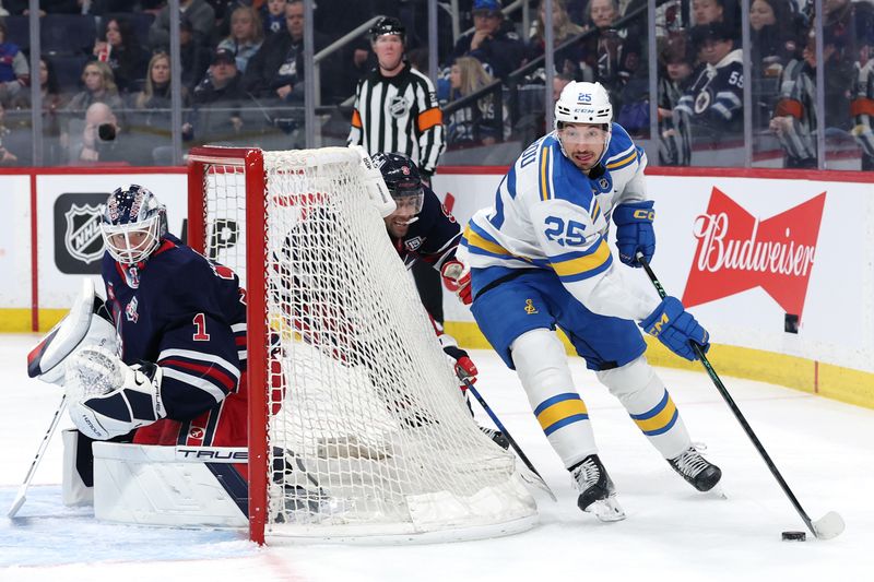 Mar 15, 2026; Winnipeg, Manitoba, CAN; St. Louis Blues right wing Jordan Kyrou (25) tries for a wrap around on Winnipeg Jets goaltender Eric Comrie (1) in the second period at Canada Life Centre. Mandatory Credit: James Carey Lauder-Imagn Images