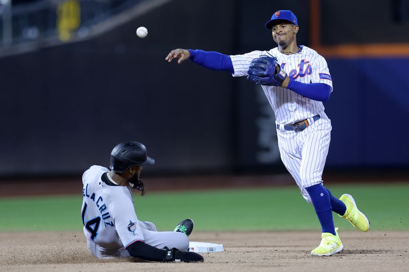 Sep 28, 2023; New York City, New York, USA; New York Mets shortstop Francisco Lindor (12) steps on second to force out Miami Marlins right fielder Bryan De La Cruz (14) and throws to first to attempt a double play on a ball hit by Marlins shortstop Garrett Hampson (not pictured) during the second inning at Citi Field. Hampson was safe at first on the play. Mandatory Credit: Brad Penner-USA TODAY Sports