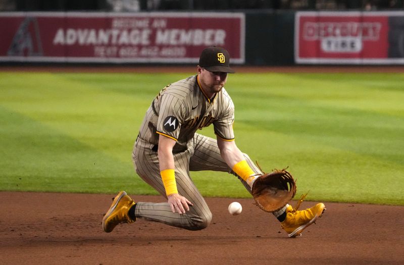 Aug 12, 2023; Phoenix, Arizona, USA; San Diego Padres first baseman Jake Cronenworth (9) fields a ground ball against the Arizona Diamondbacks during the eighth inning at Chase Field. Mandatory Credit: Joe Camporeale-USA TODAY Sports