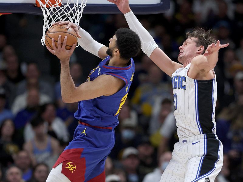 DENVER, COLORADO - JANUARY 05: Jamal Murray #27 of the Denver Nuggets goes to the basket against Moritz Wagner #21 of the Orlando Magic in the first quarter at Ball Arena on January 05, 2024 in Denver, Colorado.  NOTE TO USER: User expressly acknowledges and agrees that, by downloading and or using this photograph, User is consenting to the terms and conditions of the Getty Images License Agreement.  (Photo by Matthew Stockman/Getty Images)