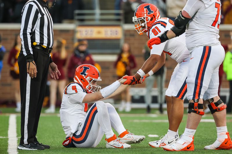 Nov 4, 2023; Minneapolis, Minnesota, USA; Illinois Fighting Illini quarterback Luke Altmyer (9) is helped off the field during the second half against the Minnesota Golden Gophers at Huntington Bank Stadium. Mandatory Credit: Matt Krohn-USA TODAY Sports