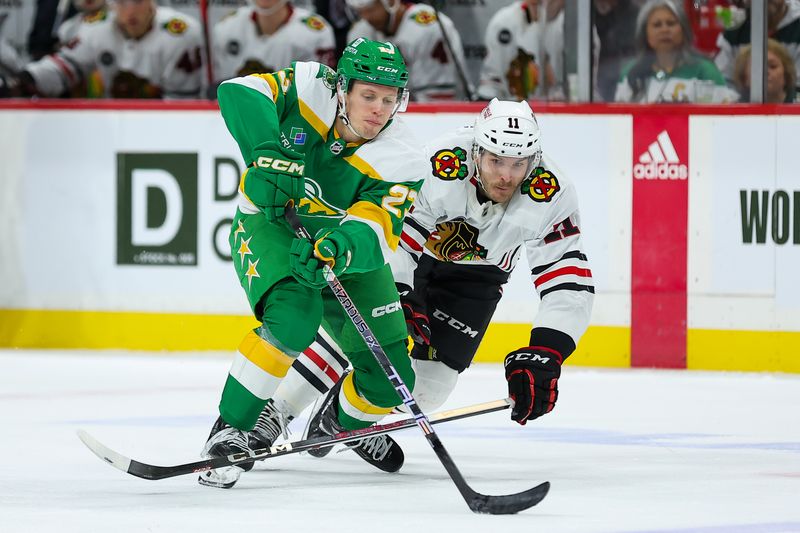 Dec 3, 2023; Saint Paul, Minnesota, USA; Minnesota Wild center Marco Rossi (23) and Chicago Blackhawks right wing Taylor Raddysh (11) compete for the puck during the second period at Xcel Energy Center. Mandatory Credit: Matt Krohn-USA TODAY Sports