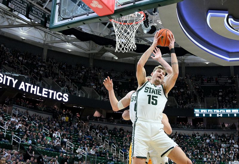 Dec 16, 2025; East Lansing, Michigan, USA;  Michigan State Spartans center Carson Cooper (15) grabs a rebound against the Toledo Rockets at Jack Breslin Student Events Center. Mandatory Credit: Dale Young-Imagn Images