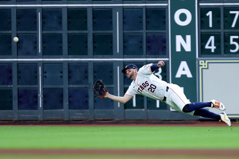 Jul 13, 2024; Houston, Texas, USA; Houston Astros left fielder Chas McCormick (20) dives to catch a fly ball for an out against the Texas Rangers during the fourth inning at Minute Maid Park. Mandatory Credit: Erik Williams-USA TODAY Sports