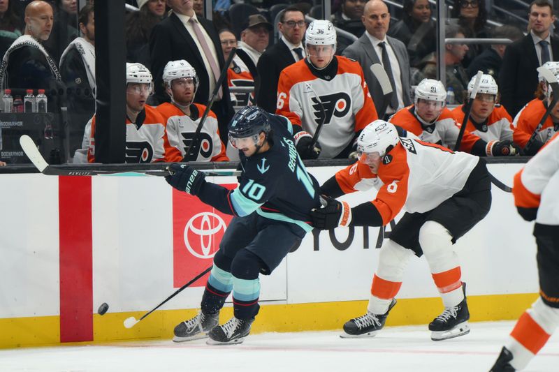 Dec 28, 2025; Seattle, Washington, USA; Seattle Kraken center Matty Beniers (10) plays thep puck while defedned by Philadelphia Flyers defenseman Travis Sanheim (6) during the second period at Climate Pledge Arena. Mandatory Credit: Steven Bisig-Imagn Images