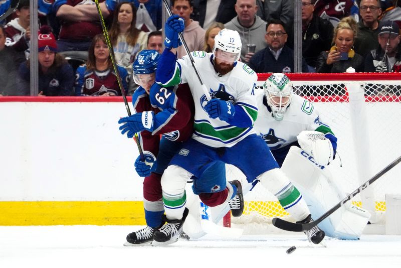 Feb 20, 2024; Denver, Colorado, USA; Vancouver Canucks defenseman Filip Hronek (17) and Colorado Avalanche left wing Artturi Lehkonen (62) battle for the puck in the third period at Ball Arena. Mandatory Credit: Ron Chenoy-USA TODAY Sports