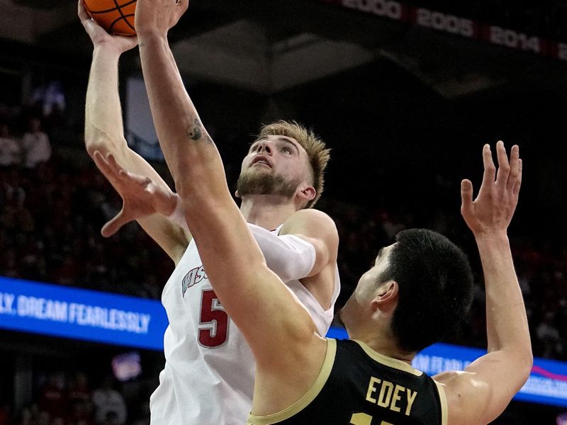 Feb 4, 2024; Madison, Wisconsin, USA; Wisconsin forward Tyler Wahl (5) shoot over Purdue center Zach Edey (15) during the second half at Kohl Center. Mandatory Credit: Mark Hoffman-USA TODAY Sports