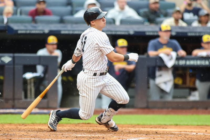 Sep 9, 2023; Bronx, New York, USA;  New York Yankees shortstop Anthony Volpe (11) hits an RBI single in the fourth inning against the Milwaukee Brewers at Yankee Stadium. Mandatory Credit: Wendell Cruz-USA TODAY Sports