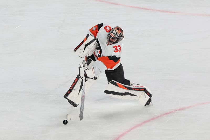 Feb 17, 2024; East Rutherford, New Jersey, USA; Philadelphia Flyers goaltender Samuel Ersson (33) plays the puck during the third period against the New Jersey Devils in a Stadium Series ice hockey game at MetLife Stadium. Mandatory Credit: Vincent Carchietta-USA TODAY Sports