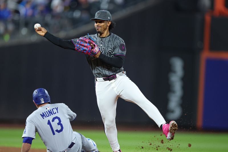 May 25, 2025; New York City, New York, USA; New York Mets shortstop Francisco Lindor (12) forces out Los Angeles Dodgers third baseman Max Muncy (13) at second base and throws to first to complete the double play on a ball hit by left fielder Andy Pages (not pictured) during the sixth inning at Citi Field. Mandatory Credit: Vincent Carchietta-Imagn Images