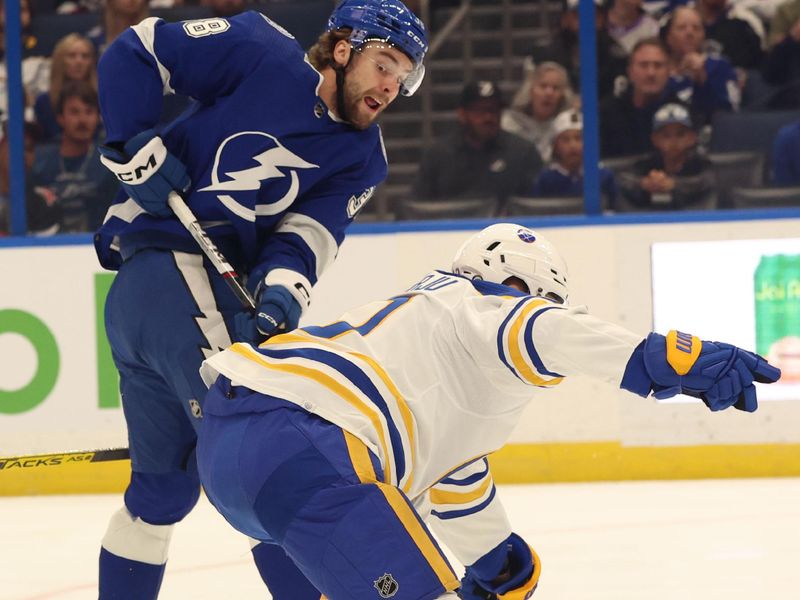 Apr 15, 2024; Tampa, Florida, USA;  Tampa Bay Lightning left wing Brandon Hagel (38) passes the puck past Buffalo Sabres defenseman Henri Jokiharju (10) during the first period at Amalie Arena. Mandatory Credit: Kim Klement Neitzel-USA TODAY Sports