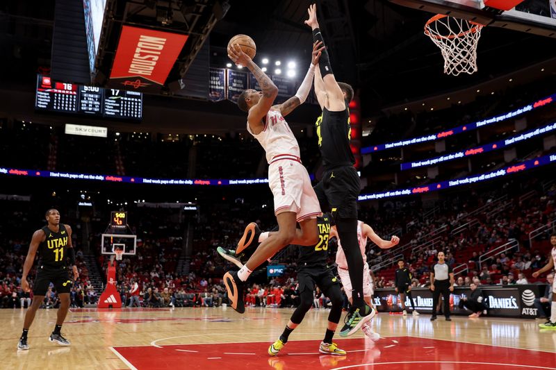 HOUSTON, TEXAS - JANUARY 20: Jabari Smith Jr. #10 of the Houston Rockets shoots the ball while defended by Walker Kessler #24 of the Utah Jazz in the first half at Toyota Center on January 20, 2024 in Houston, Texas.  NOTE TO USER: User expressly acknowledges and agrees that, by downloading and or using this photograph, User is consenting to the terms and conditions of the Getty Images License Agreement. (Photo by Tim Warner/Getty Images)