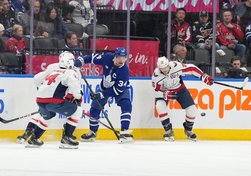 Dec 6, 2024; Toronto, Ontario, CAN; Toronto Maple Leafs center Auston Matthews (34) battles for the puck with Washington Capitals center Nic Dowd (26) during the first period at Scotiabank Arena. Mandatory Credit: Nick Turchiaro-Imagn Images