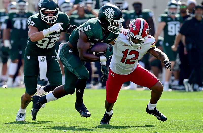 Sep 23, 2023; East Lansing, Michigan, USA;  Michigan State Spartans running back Nathan Carter (5) runs upfield in the first quarter against Maryland Terrapins defensive back Dante Trader Jr. (12) at Spartan Stadium. Mandatory Credit: Dale Young-USA TODAY Sports