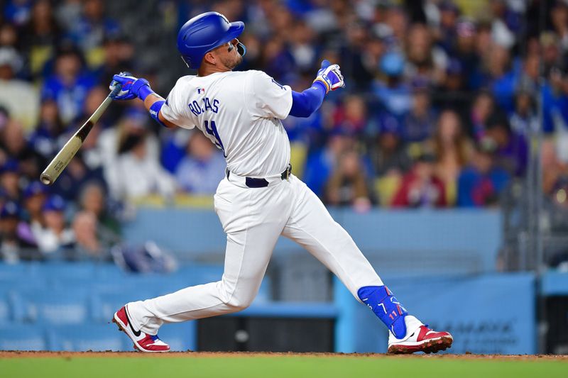 Apr 3, 2024; Los Angeles, California, USA; Los Angeles Dodgers shortstop Miguel Rojas (11) hits a solo home run against the San Francisco Giants during the fourth inning at Dodger Stadium. Mandatory Credit: Gary A. Vasquez-USA TODAY Sports