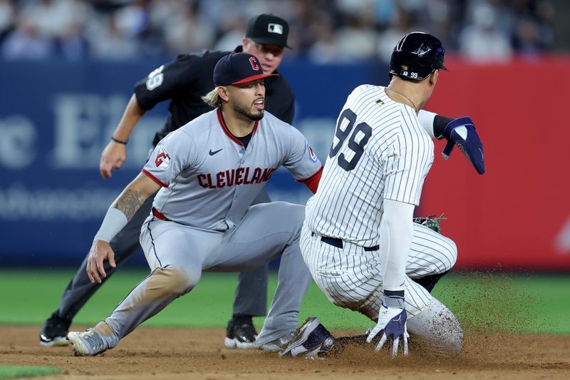 Jun 3, 2025; Bronx, New York, USA; Cleveland Guardians shortstop Gabriel Arias (13) tags out New York Yankees right fielder Aaron Judge (99) trying to steal second base during the eighth inning at Yankee Stadium. Mandatory Credit: Brad Penner-Imagn Images
