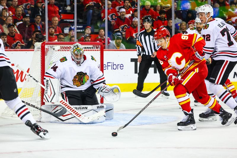 Oct 15, 2024; Calgary, Alberta, CAN; Calgary Flames left wing Andrei Kuzmenko (96) controls the puck in front of Chicago Blackhawks goaltender Petr Mrazek (34) during the second period at Scotiabank Saddledome. Mandatory Credit: Sergei Belski-Imagn Images