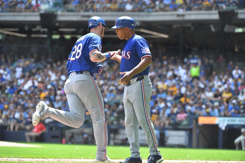 Jun 26, 2024; Milwaukee, Wisconsin, USA; Texas Rangers catcher Jonah Heim (28) celebrates with third base coach Tony Beasley (27) after hitting a home run against the Milwaukee Brewers in the fourth inning at American Family Field. Mandatory Credit: Michael McLoone-USA TODAY Sports