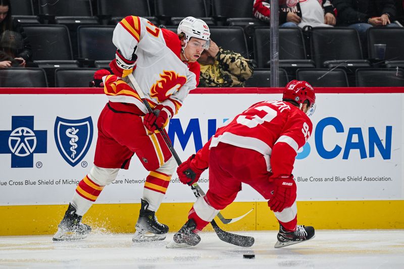 Nov 27, 2024; Detroit, Michigan, USA; Calgary Flames center Connor Zary (47) pass the puck around Detroit Red Wings right wing Alex DeBrincat (93) during the second period at Little Caesars Arena. Mandatory Credit: Tim Fuller-Imagn Images