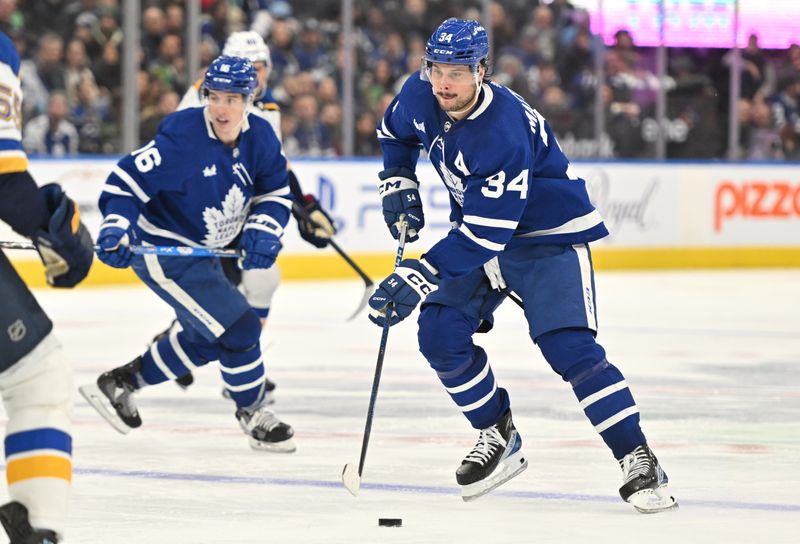 Jan 3, 2023; Toronto, Ontario, CAN; Toronto Maple Leafs forward Auston Matthews (34) skates with the puck ahead of forward Mitch Marner (16) against the St. Louis Blues in the third period at Scotiabank Arena. Mandatory Credit: Dan Hamilton-USA TODAY Sports