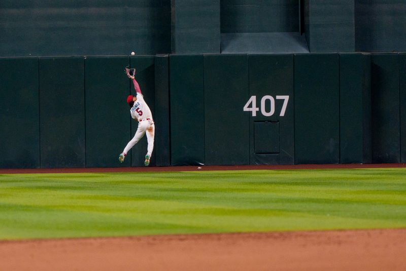 Apr 26, 2025; Phoenix, Arizona, USA;  Arizona Diamondbacks outfielder Alek Thomas (5) reaches but does not make the catch in the seventh inning against the Atlanta Braves at Chase Field. Mandatory Credit: Allan Henry-Imagn Images