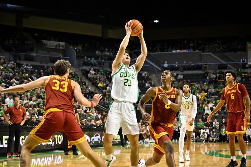 Dec 2, 2025; Eugene, Oregon, USA; Oregon Ducks guard Wei Lin (23) drives to the basket between Southern California Trojans forward Jaden Brownell (33) and guard Jerry Easter II (8) during the first half at Matthew Knight Arena. Mandatory Credit: Craig Strobeck-Imagn Images