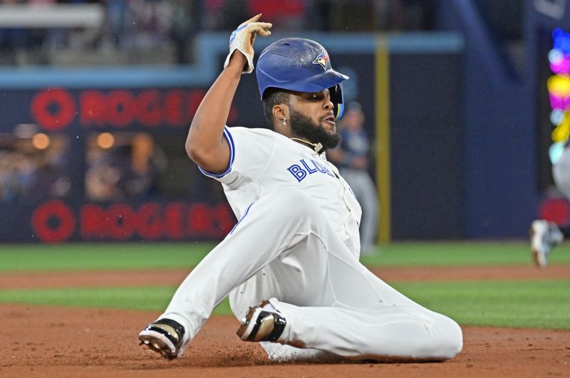 May 14, 2025; Toronto, Ontario, CAN; Toronto Blue Jays first baseman Vladimir Guerrero Jr. (27) slides safely into third base against the Tampa Bay Rays in the first inning at Rogers Centre. Mandatory Credit: Dan Hamilton-Imagn Images