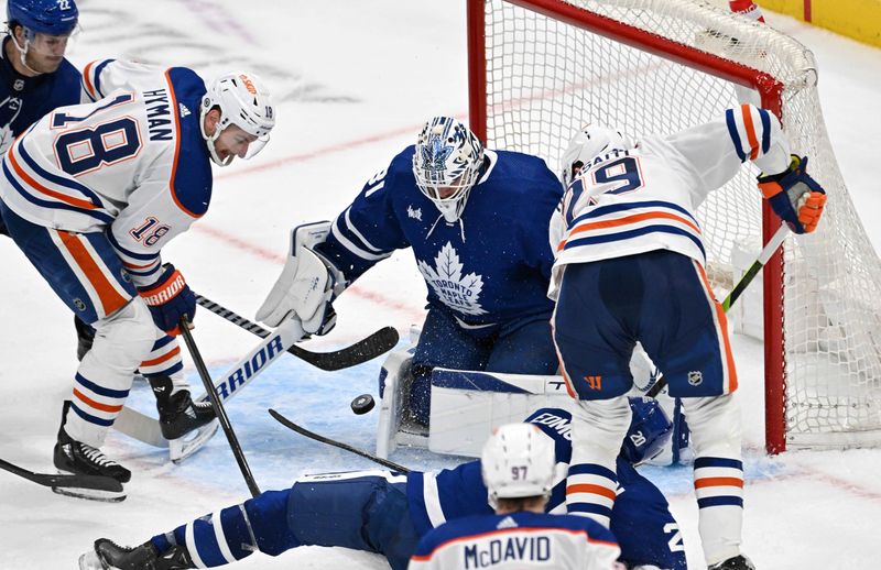 Mar 23, 2024; Toronto, Ontario, CAN; Toronto Maple Leafs goalie Martin Jones (31) makes a save as Edmonton Oilers forwards Zach Hyman (18) and Leon Draisaitl (29) pursue the rebound in the third period at Scotiabank Arena. Mandatory Credit: Dan Hamilton-USA TODAY Sports