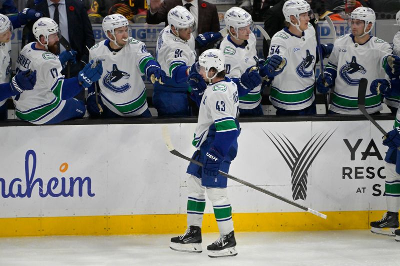 Nov 5, 2024; Anaheim, California, USA; Vancouver Canucks defenseman Quinn Hughes (43) in congratulated at the bench after scoring a goal in the second period against the Anaheim Ducks at Honda Center. Mandatory Credit: Jayne Kamin-Oncea-Imagn Images