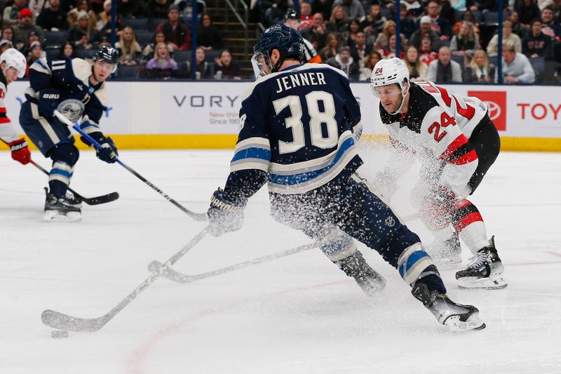 Jan 19, 2024; Columbus, Ohio, USA; Columbus Blue Jackets center Boone Jenner (38) overskates the puck as New Jersey Devils defenseman Colin Miller (24) defends during the third period at Nationwide Arena. Mandatory Credit: Russell LaBounty-USA TODAY Sports