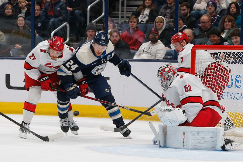 Dec 31, 2024; Columbus, Ohio, USA; Carolina Hurricanes center Tyson Jost (27) and Columbus Blue Jackets center Mathieu Olivier (24) Bastille for the puck during the first period at Nationwide Arena. Mandatory Credit: Russell LaBounty-Imagn Images