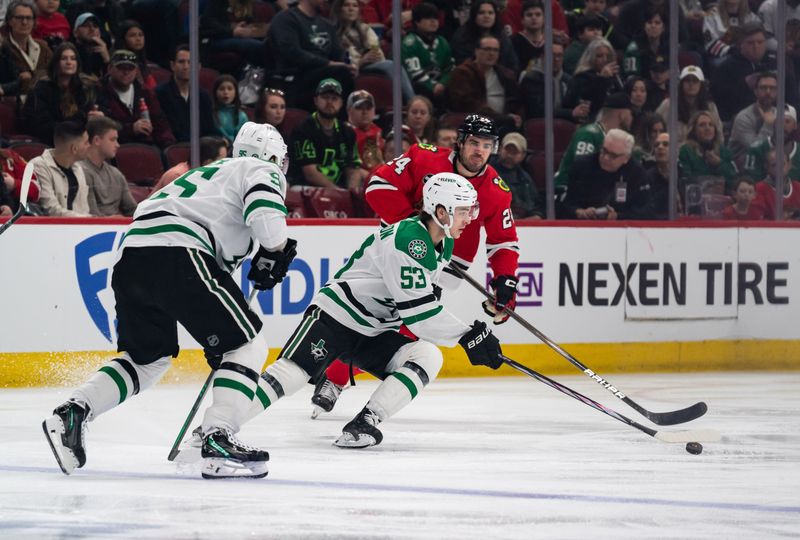 Apr 6, 2024; Chicago, Illinois, USA; Dallas Stars center Wyatt Johnston (53) keeps the puck away from Chicago Blackhawks defenseman Jaycob Megna (24) during the first period at United Center. Mandatory Credit: Seeger Gray-USA TODAY Sports