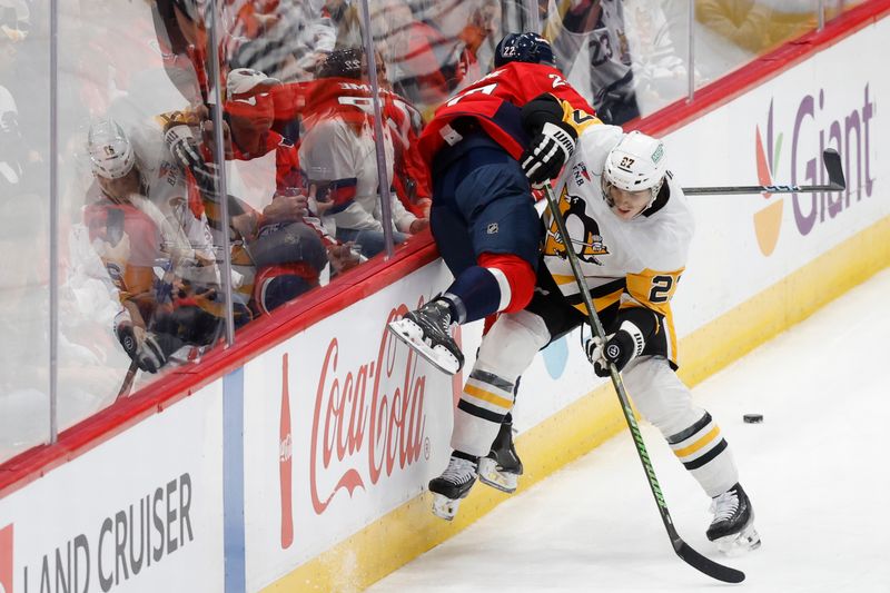 Nov 8, 2024; Washington, District of Columbia, USA; Pittsburgh Penguins defenseman Ryan Graves (27) checks Washington Capitals right wing Brandon Duhaime (22) while battling for the puck in the first period at Capital One Arena. Mandatory Credit: Geoff Burke-Imagn Images