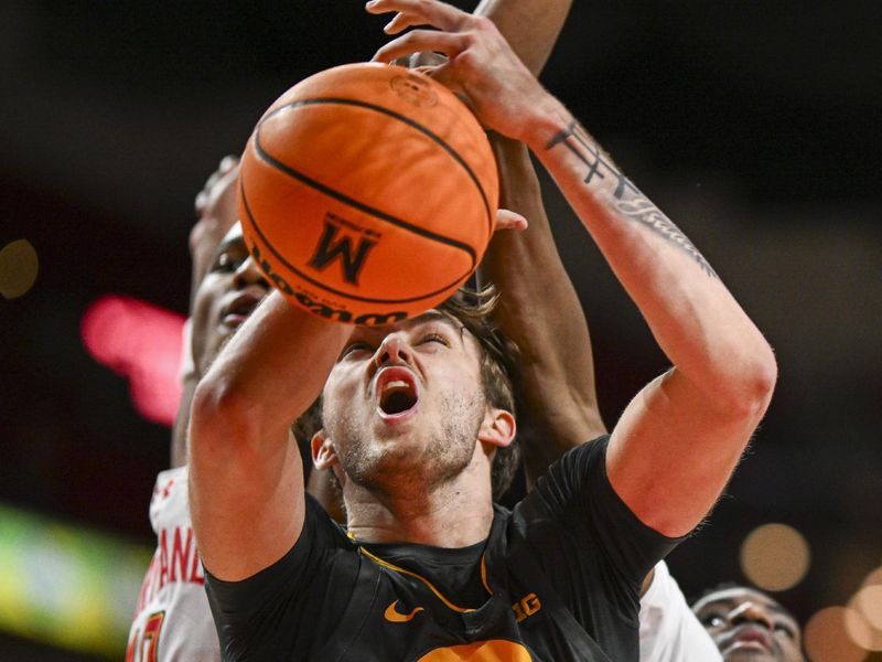 Feb 14, 2024; College Park, Maryland, USA;  Iowa Hawkeyes forward Owen Freeman (32) reacts while Maryland Terrapins forward Julian Reese (10) and forward Mady Traore (14) defend from behind  at Xfinity Center. Mandatory Credit: Tommy Gilligan-USA TODAY Sports