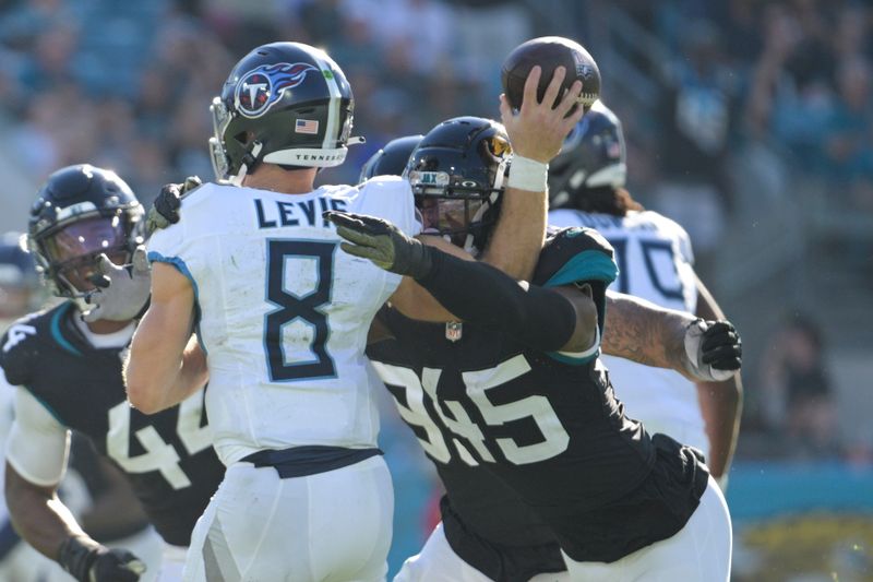 Tennessee Titans quarterback Will Levis (8) is hit by Jacksonville Jaguars linebacker K'Lavon Chaisson (45) as he throws a pass during the second half of an NFL football game, Sunday, Nov. 19, 2023, in Jacksonville, Fla. (AP Photo/Phelan M. Ebenhack)