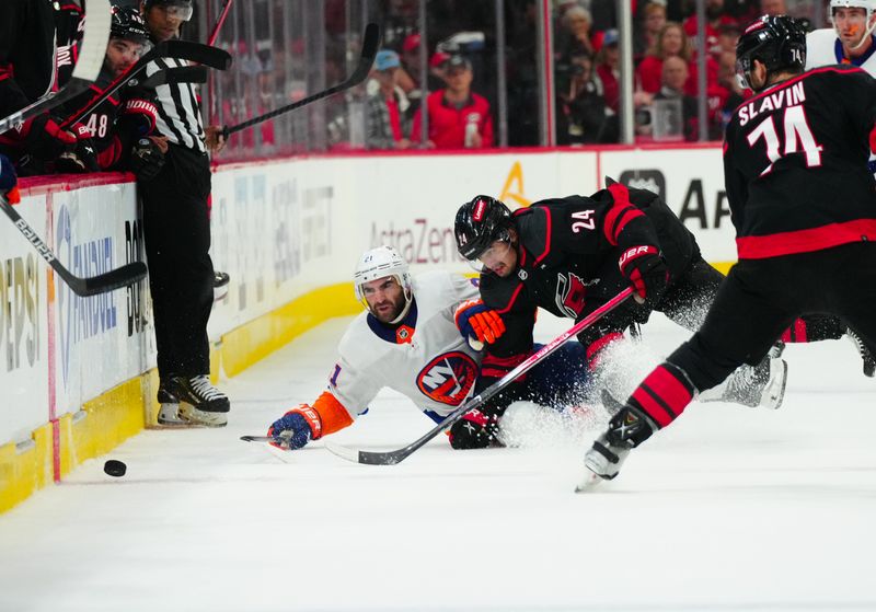 Apr 30, 2024; Raleigh, North Carolina, USA; New York Islanders center Kyle Palmieri (21) and Carolina Hurricanes center Seth Jarvis (24) battle for the puck during the second period in game five of the first round of the 2024 Stanley Cup Playoffs at PNC Arena. Mandatory Credit: James Guillory-USA TODAY Sports