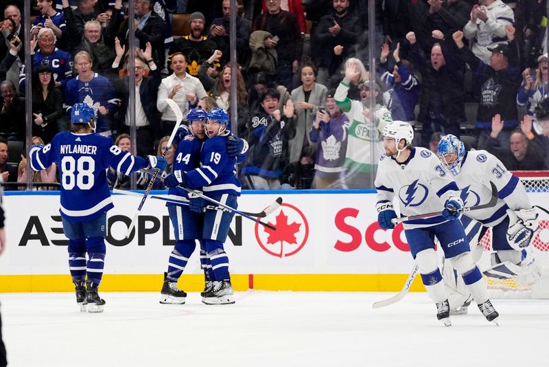 Nov 6, 2023; Toronto, Ontario, CAN; Toronto Maple Leafs defenseman Morgan Rielly (44) and forward William Nylander (88) congratulate forward Calle Jarnkrok (19) after his game winning goal against the Tampa Bay Lightning during overtime at Scotiabank Arena. Mandatory Credit: John E. Sokolowski-USA TODAY Sports