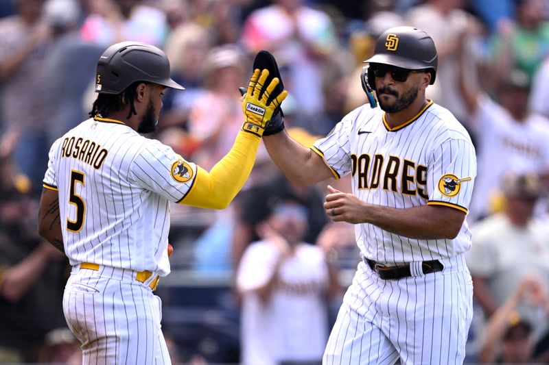 Sep 20, 2023; San Diego, California, USA; San Diego Padres center fielder Trent Grisham (right) is congratulated by third baseman Eguy Rosario (5) after scoring a run against the Colorado Rockies during the seventh inning at Petco Park. Mandatory Credit: Orlando Ramirez-USA TODAY Sports