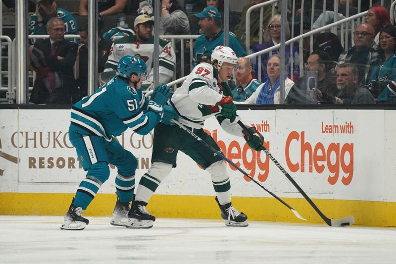 Apr 13, 2024; San Jose, California, USA; San Jose Sharks right wing Collin Graf (51) and Minnesota Wild left wing Kirill Kaprizov (97) fight for the puck during the first period at SAP Center at San Jose. Mandatory Credit: David Gonzales-USA TODAY Sports