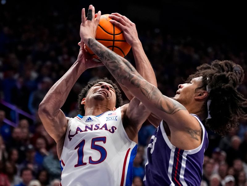 Jan 6, 2024; Lawrence, Kansas, USA; Kansas Jayhawks guard Kevin McCullar Jr. (15) goes up for a shot against TCU Horned Frogs guard Micah Peavy (0) during the second half at Allen Fieldhouse. Mandatory Credit: Jay Biggerstaff-USA TODAY Sports