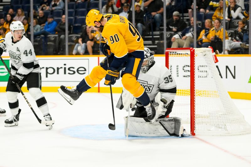 Nov 4, 2024; Nashville, Tennessee, USA;  Los Angeles Kings goaltender Darcy Kuemper (35) blocks the shot of from Nashville Predators left wing Filip Forsberg (9) as Nashville Predators center Ryan O'Reilly (90) jumps during the third period at Bridgestone Arena. Mandatory Credit: Steve Roberts-Imagn Images