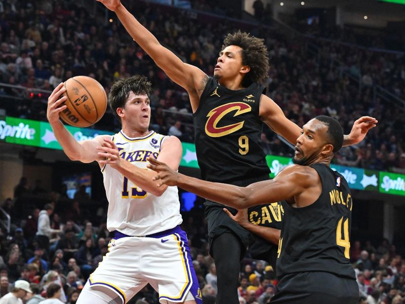 CLEVELAND, OHIO - NOVEMBER 25: Austin Reaves #15 of the Los Angeles Lakers passes around Craig Porter #9 and Evan Mobley #4 of the Cleveland Cavaliers during the second quarter at Rocket Mortgage Fieldhouse on November 25, 2023 in Cleveland, Ohio. NOTE TO USER: User expressly acknowledges and agrees that, by downloading and or using this photograph, User is consenting to the terms and conditions of the Getty Images License Agreement. (Photo by Jason Miller/Getty Images)
