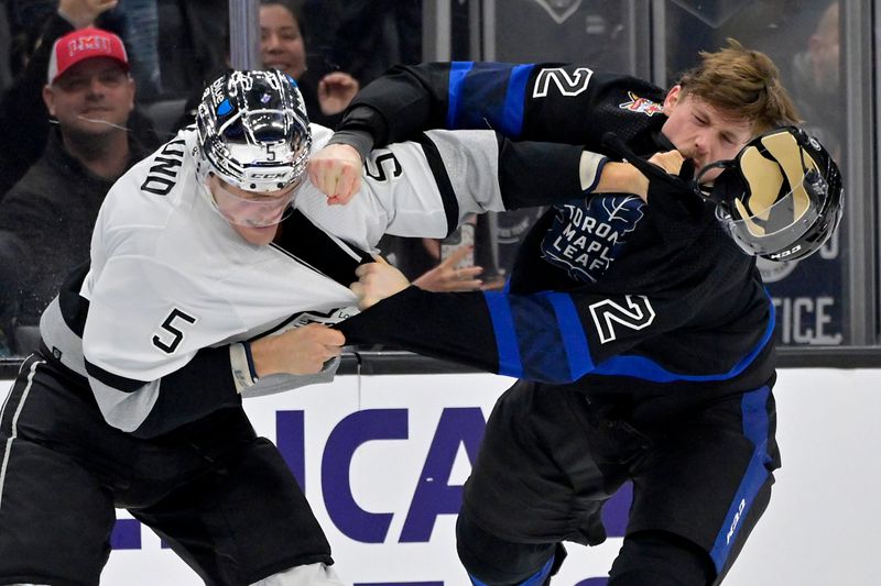 Jan 2, 2024; Los Angeles, California, USA; Los Angeles Kings defenseman Andreas Englund (5) and Toronto Maple Leafs defenseman Simon Benoit (2) fight during the third period at Crypto.com Arena. Mandatory Credit: Jayne Kamin-Oncea-USA TODAY Sports